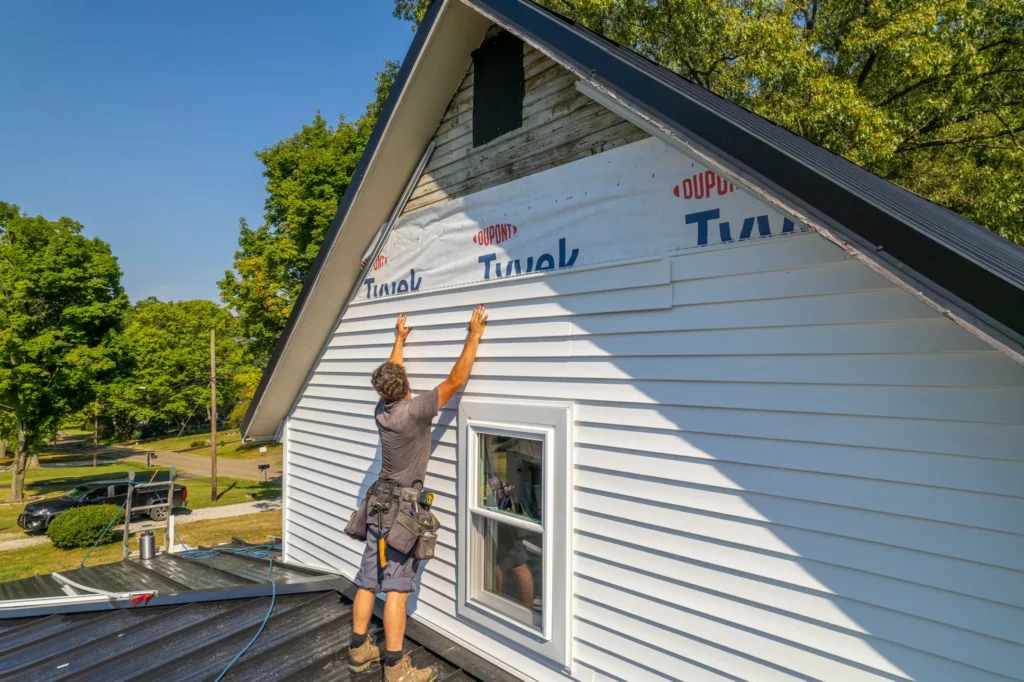 what does hail damage look like on siding worker installing white siding
