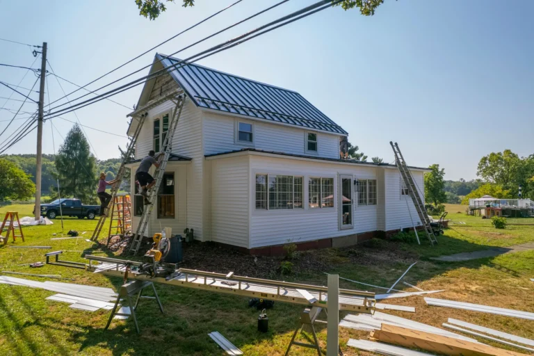storm damage siding repair big white house ladders against wall