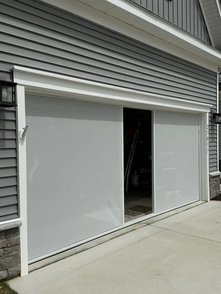Modern white garage with frosted glass doors partially open, showing interior storage space.