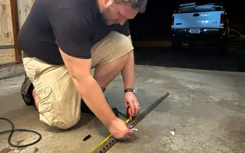 Technician measuring alignment for off-track garage door repair
