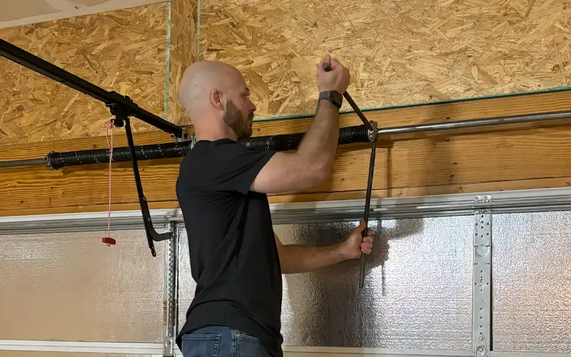 Professional garage door repair technician fixing torsion spring mechanism