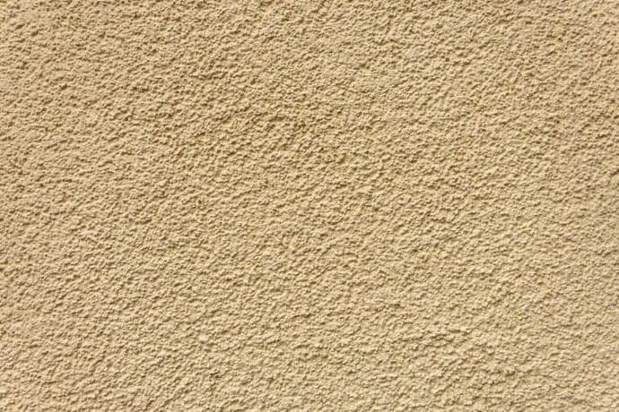 Beige stucco wall with rough texture