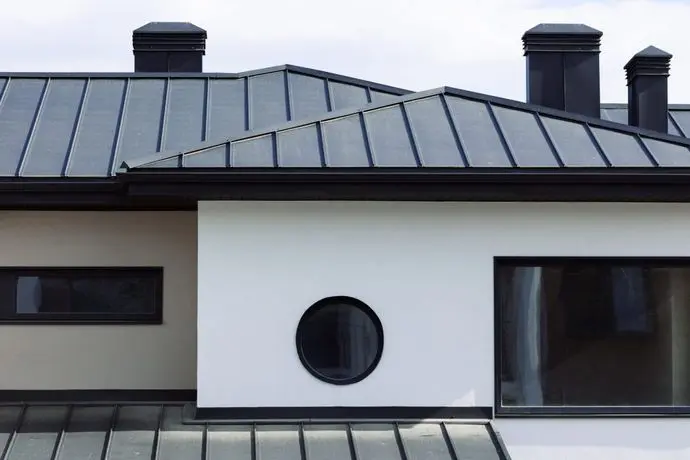 metal roof colors Many modern white cottages with panoramic windows on the background of the park and blue sky.
