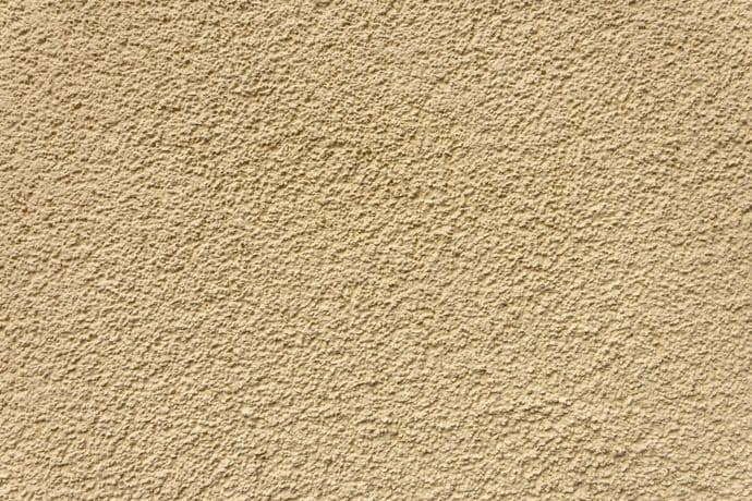 Beige stucco wall with rough texture