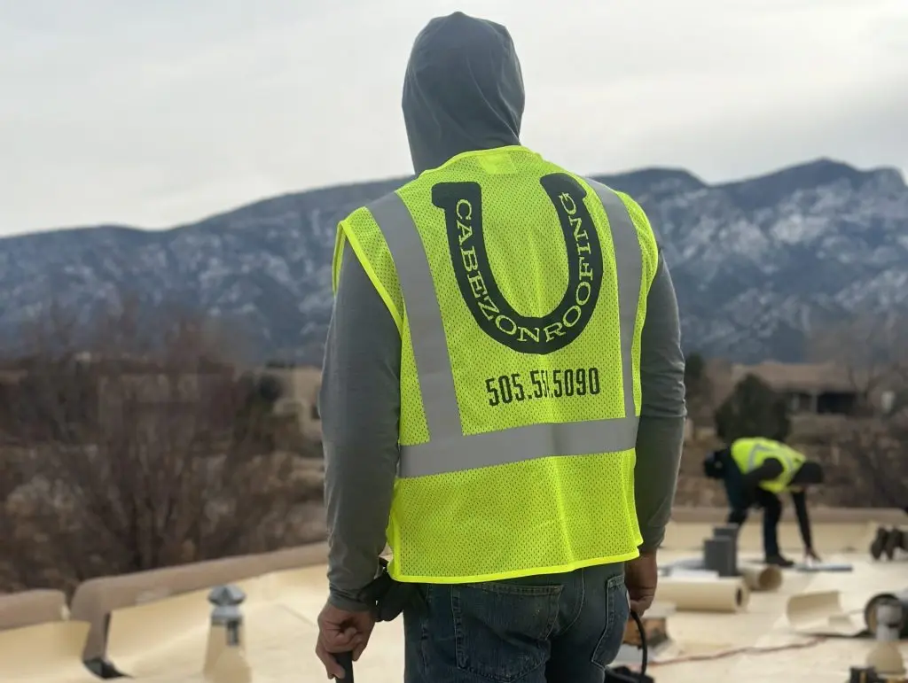 guy standing on top of flat roof under construction