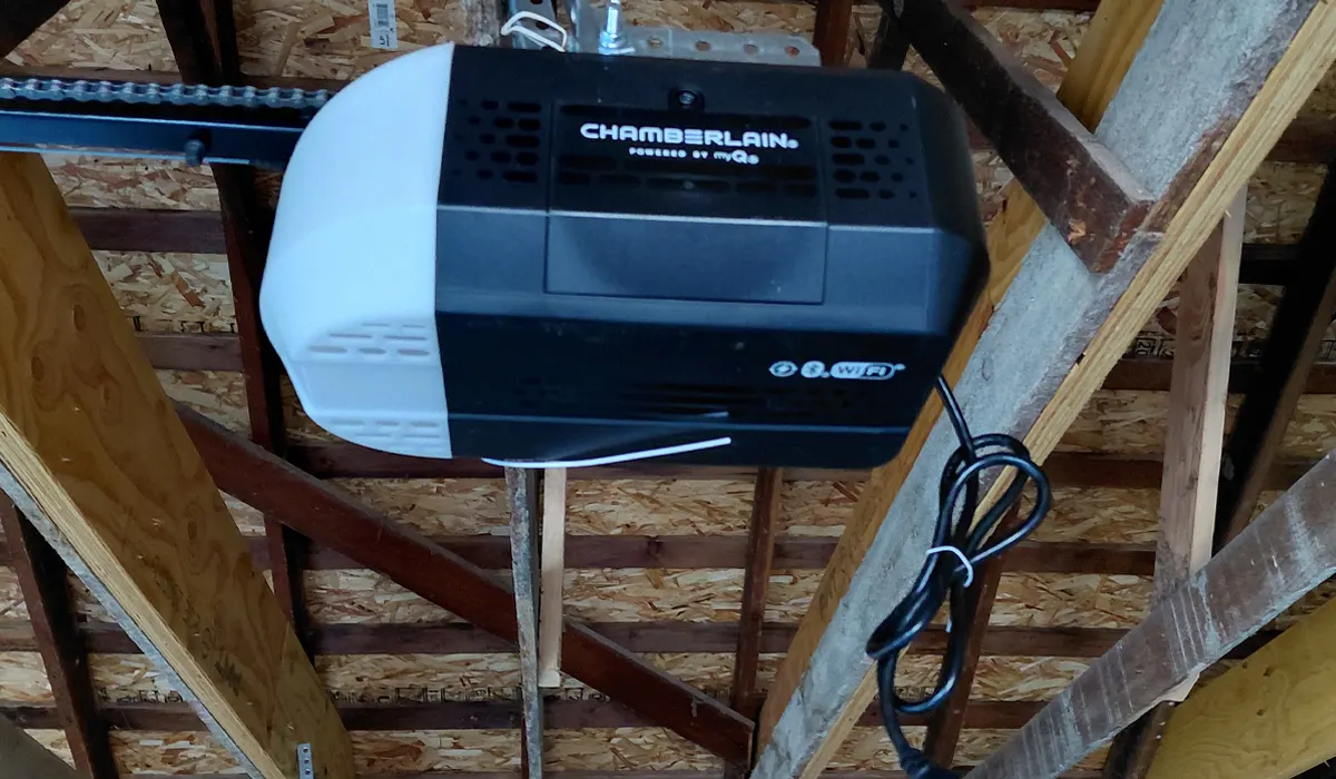 Chamberlain garage door opener installed on the ceiling joists of a garage
