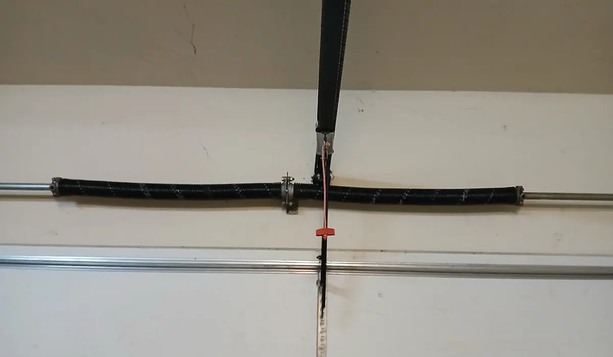 John Spero tuning up a garage door's springs and track