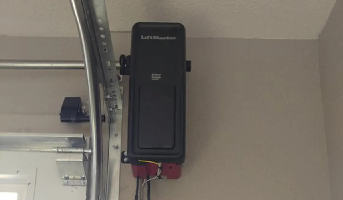 Wall-mounted garage door opener with its safety label and wall control