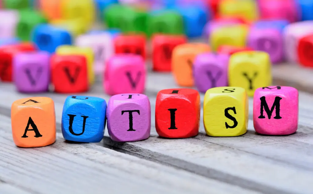 Autism spelled out with beads on wooden table