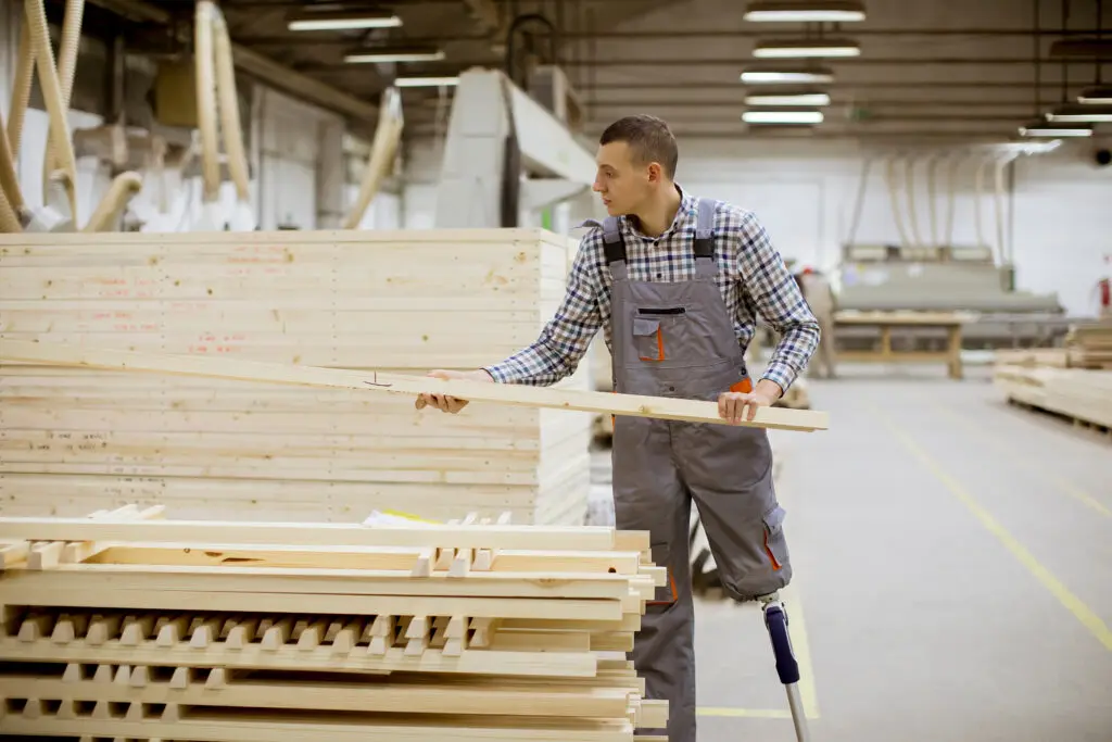 Amputee with an artificial leg working at a furniture factory