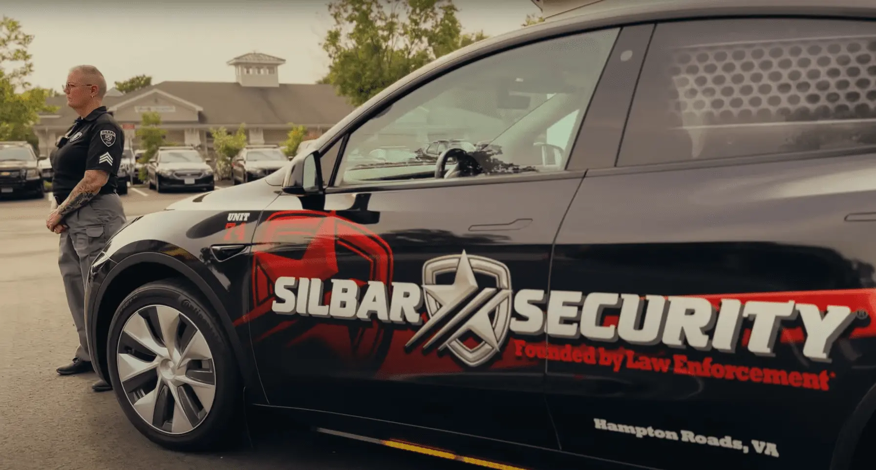 Silbar Security guard standing in front of a Silbar Tesla vehicle