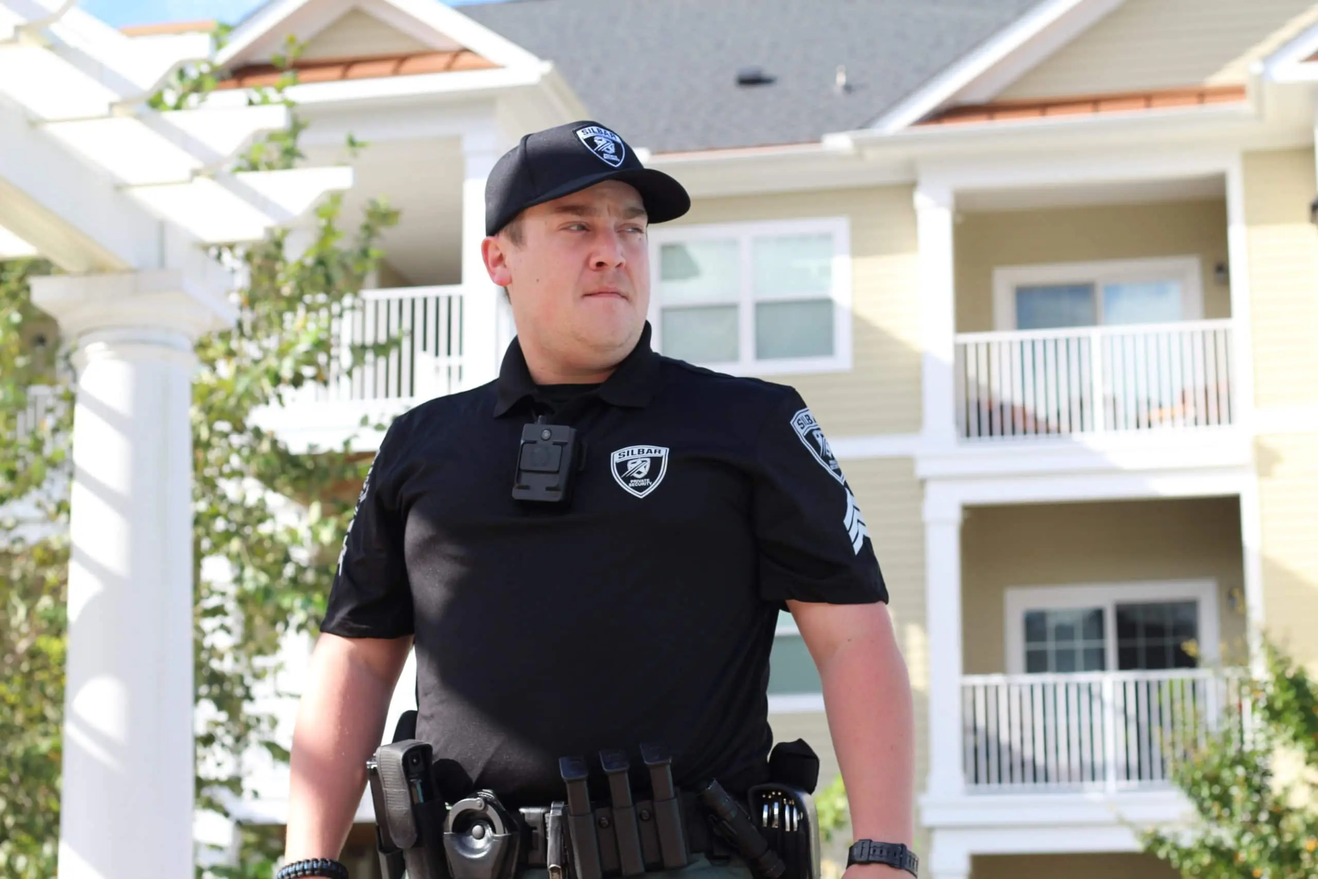 A uniformed security guard standing outside a building