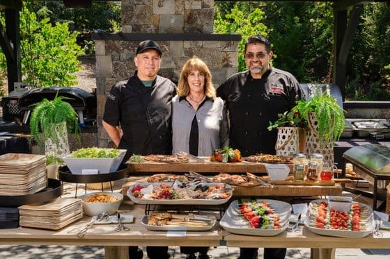 Guests gathered at the grazing table during a backyard graduation celebration catered by Handheld Catering in Los Altos