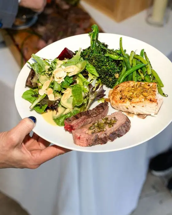 A wedding dinner plate with heirloom beet salad, grilled flank steak, and grilled ciabatta, catered by Handheld Catering