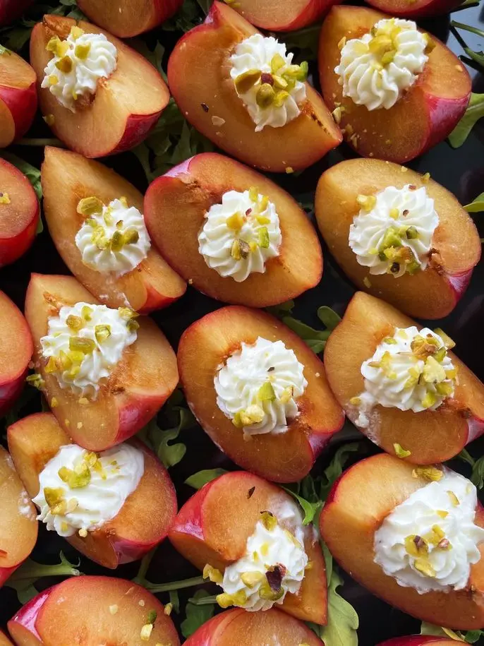 Fresh stone fruit appetizers with cream and pistachios, a gluten-free option by Handheld Catering