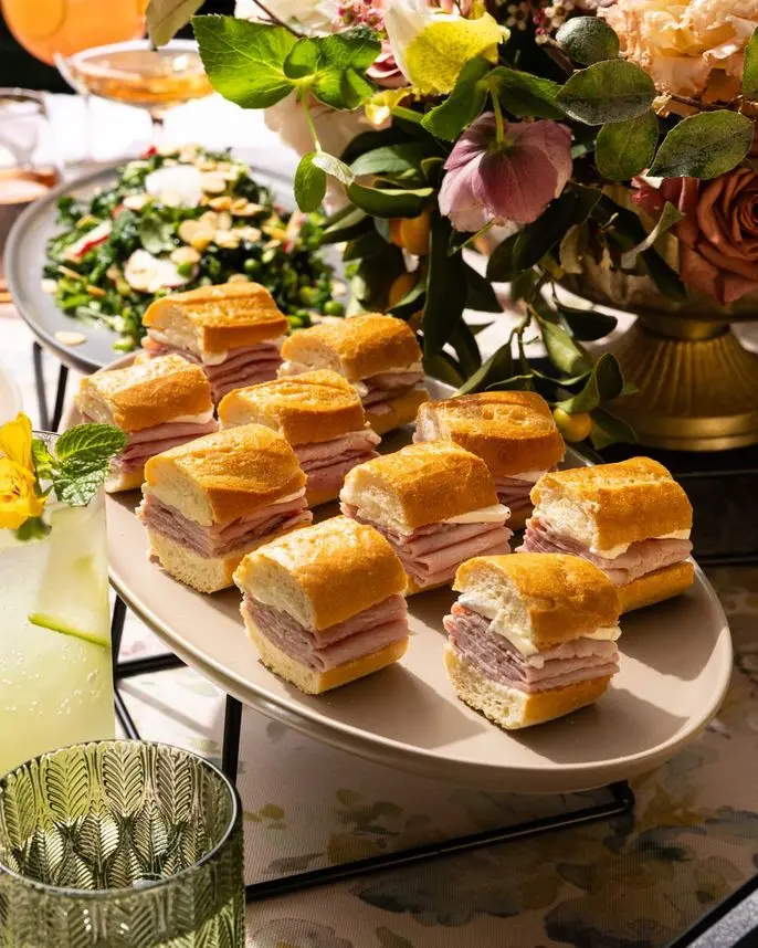 Mini jambon beurre sandwiches with spring mocktails and florals at a birthday party by Handheld Catering