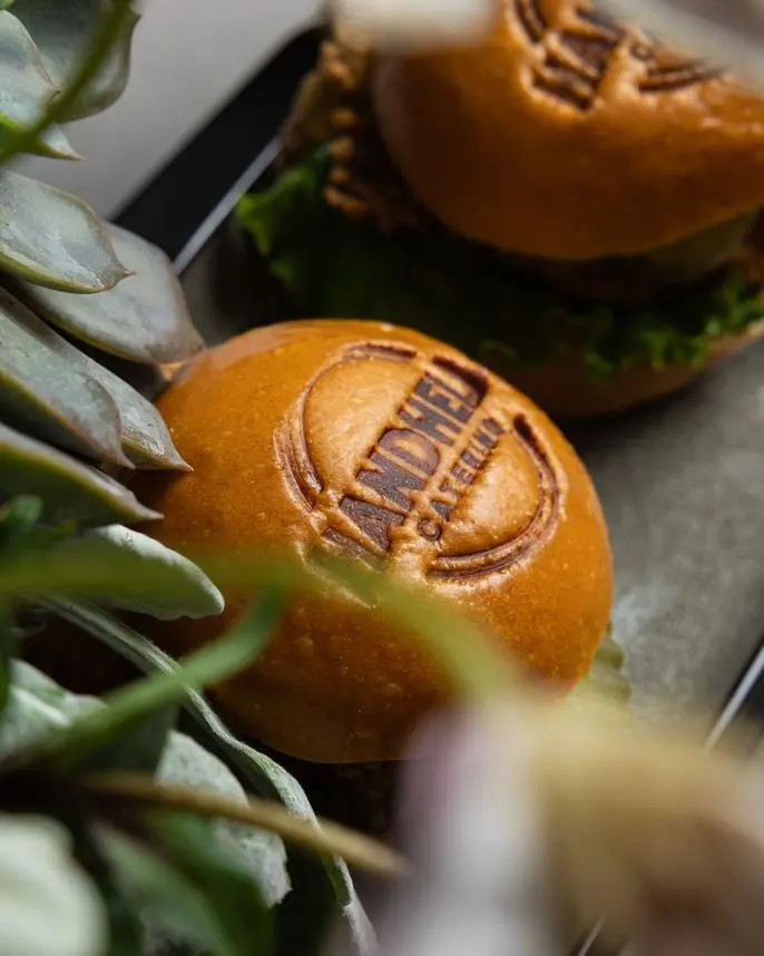 Handheld Catering branded brioche slider bun with pulled pork at a small party event