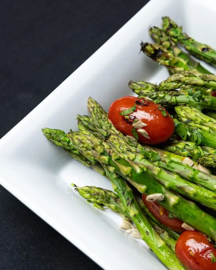 Grilled asparagus with roasted cherry tomatoes, a vegan side dish by Handheld Catering