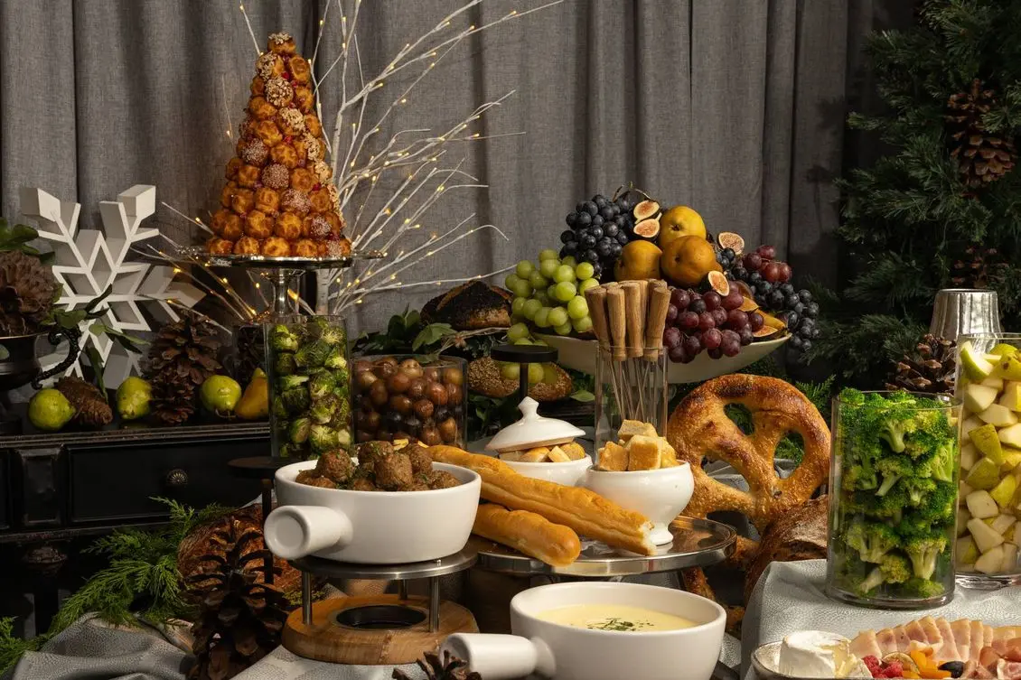 Handheld Catering holiday grazing table with a croquembouche, warm fondue and seasonal fruit