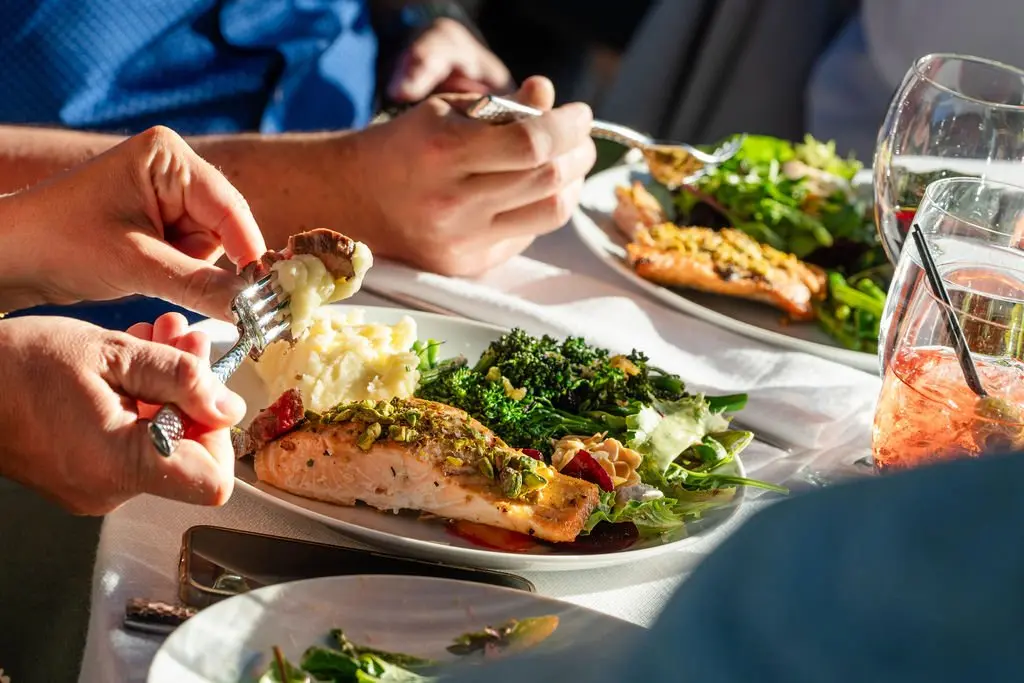 Handheld Catering herb-crusted salmon with broccolini and mashed potatoes at a Bay Area wedding, by Ken Hamel Photo