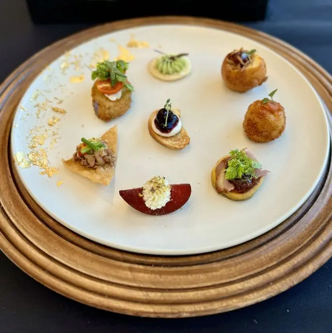 Assorted passed hors d'oeuvres platter with arancini, crostini, and artisan bites at a birthday party