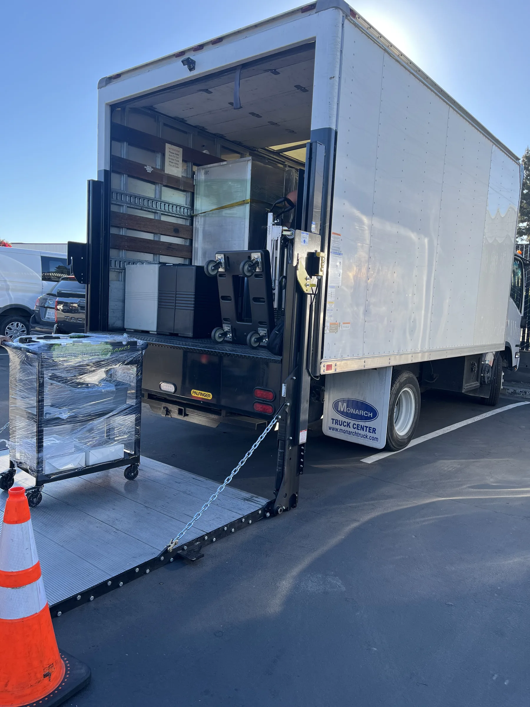 Handheld Catering box truck with liftgate unloading oversized kitchen equipment for Silicon Valley corporate March Madness pop-up field kitchen