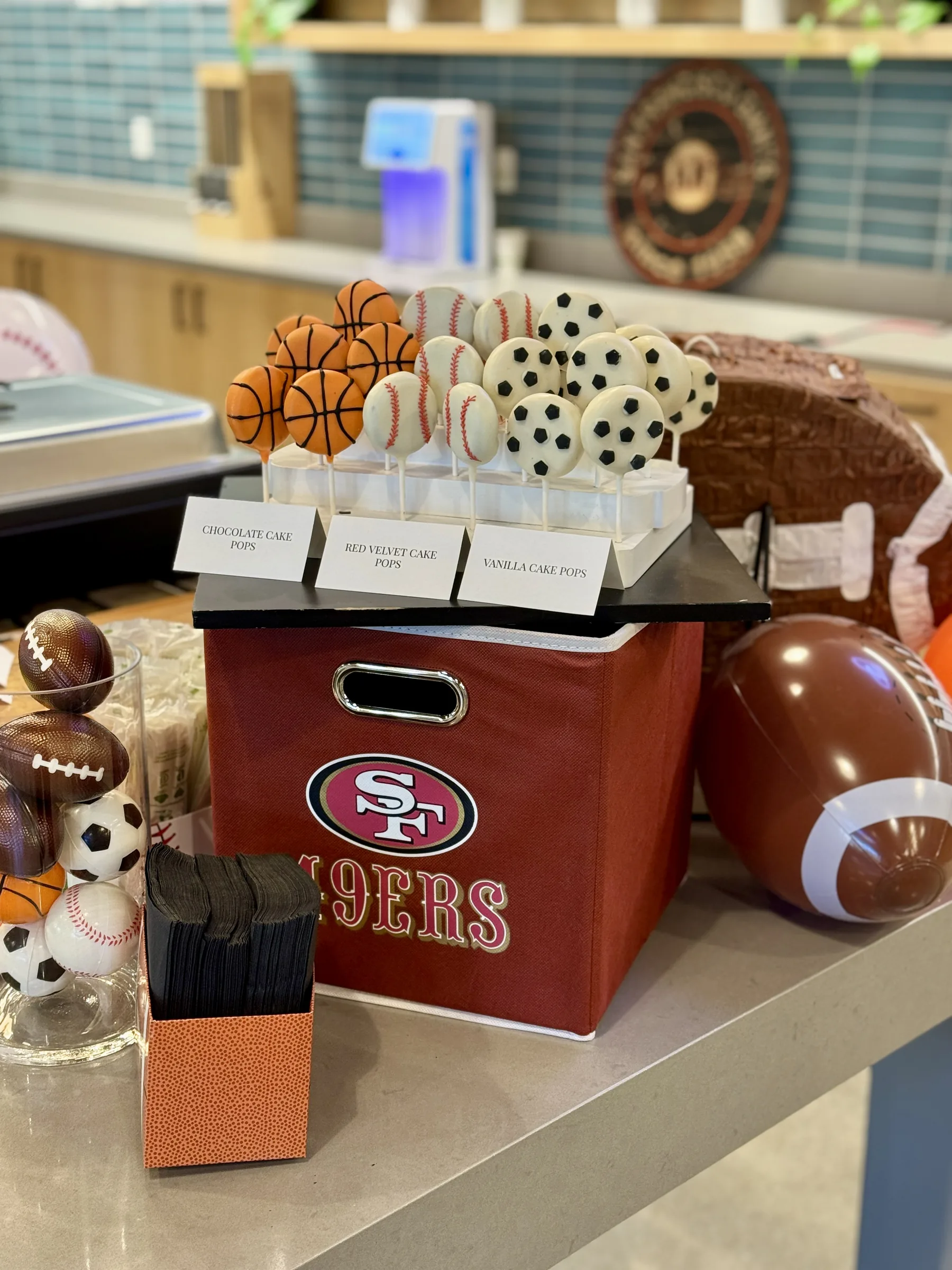 Silicon Valley sports-themed dessert display by Handheld Catering featuring custom sports cake pops, churro loops, and cotton candy station for March Madness corporate event