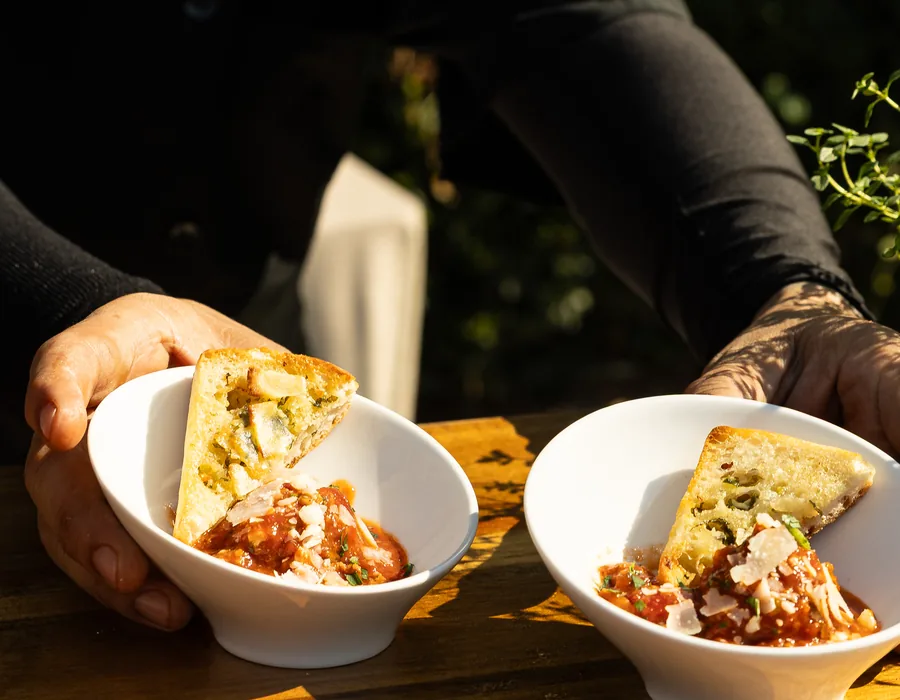 Handheld Catering staff serving family-style bowls at an outdoor San Jose event
