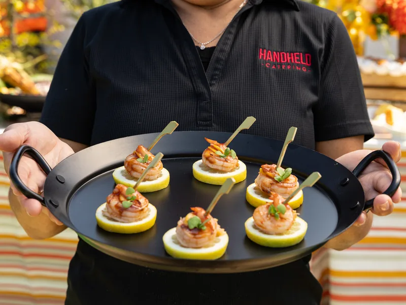 Handheld Catering staff passing shrimp appetizers on a tray at a Silicon Valley wedding reception