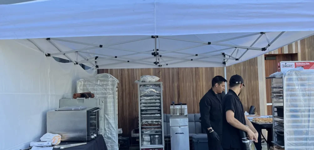 Handheld Catering pop-up field kitchen tent with chefs preparing food on-site at a Silicon Valley corporate March Madness tailgate for 200 employees.