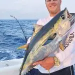 Man Holding a Fish on Boat