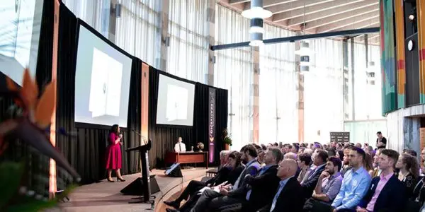 Woman speaking on stage in front of audience
