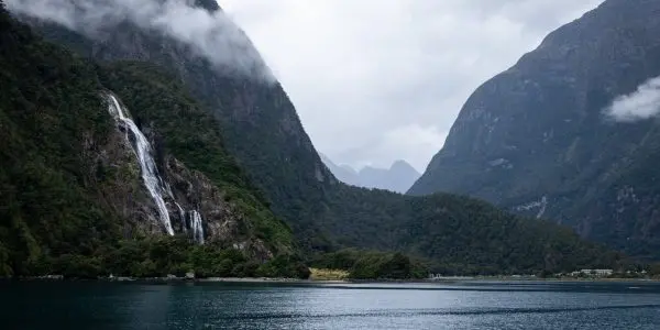 Misty waterfall, mountains and lake