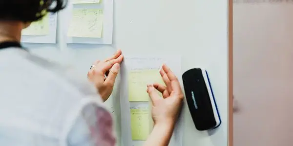 Participant sticks post-it to whiteboard during Creative HQ's workshop