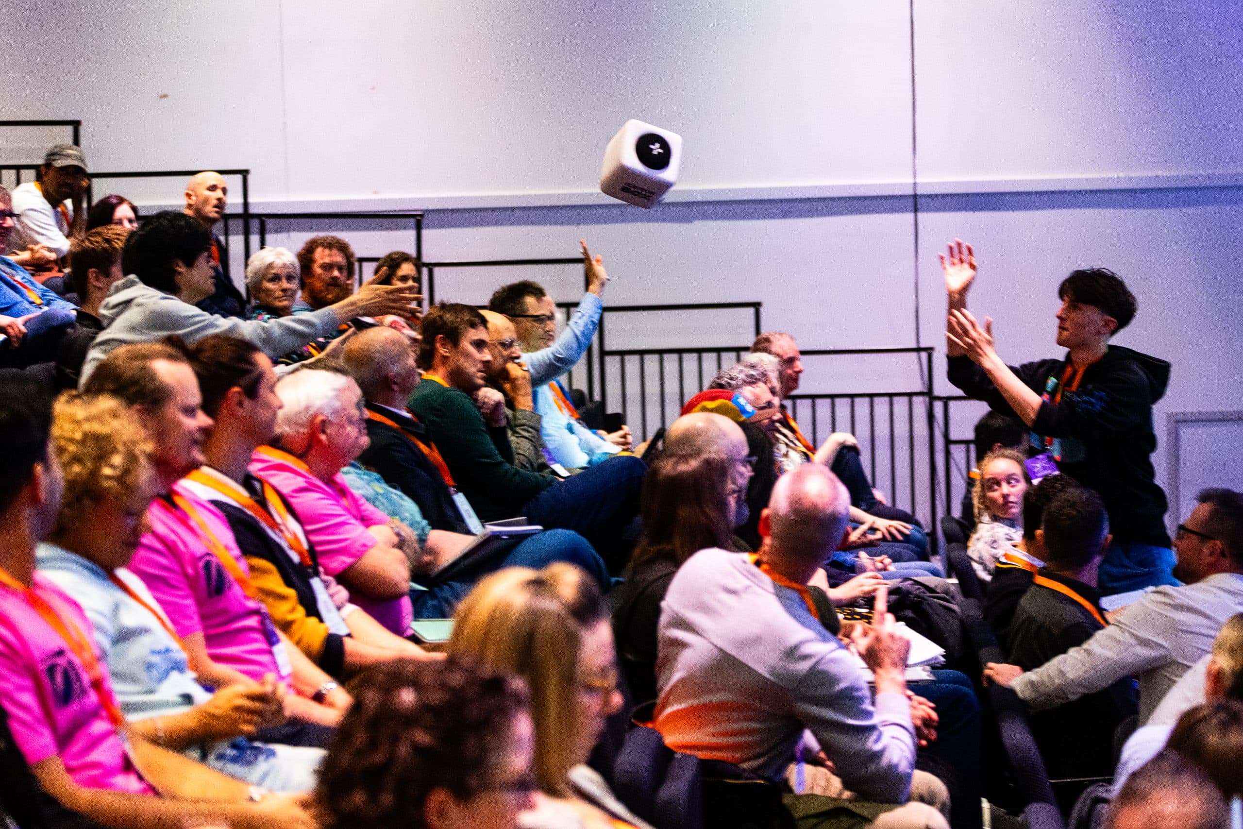 Conference attendees throwing a catch box microphone