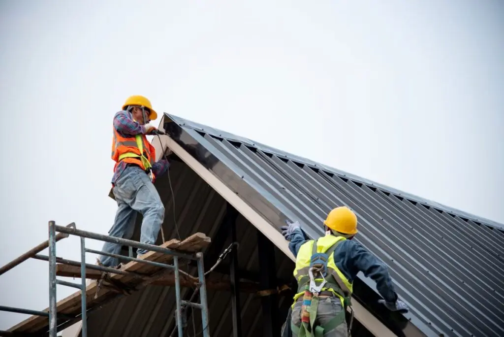 two workers installing metal roof