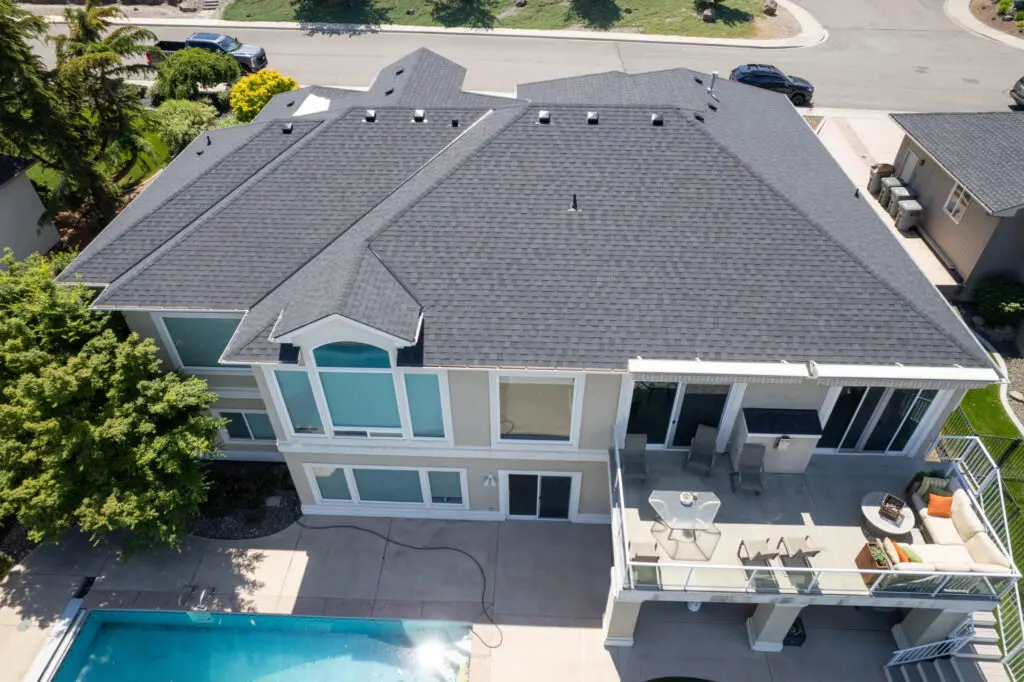 Overhead view of Richland roof installation on a large home using a black and gray shingle roof.