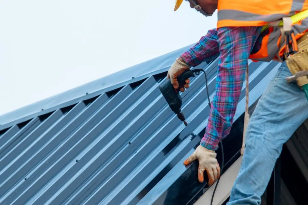 worker installing metal roof