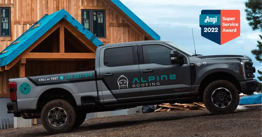 Alpine Roofing truck in front of wood cabin with Angi Super Service Award