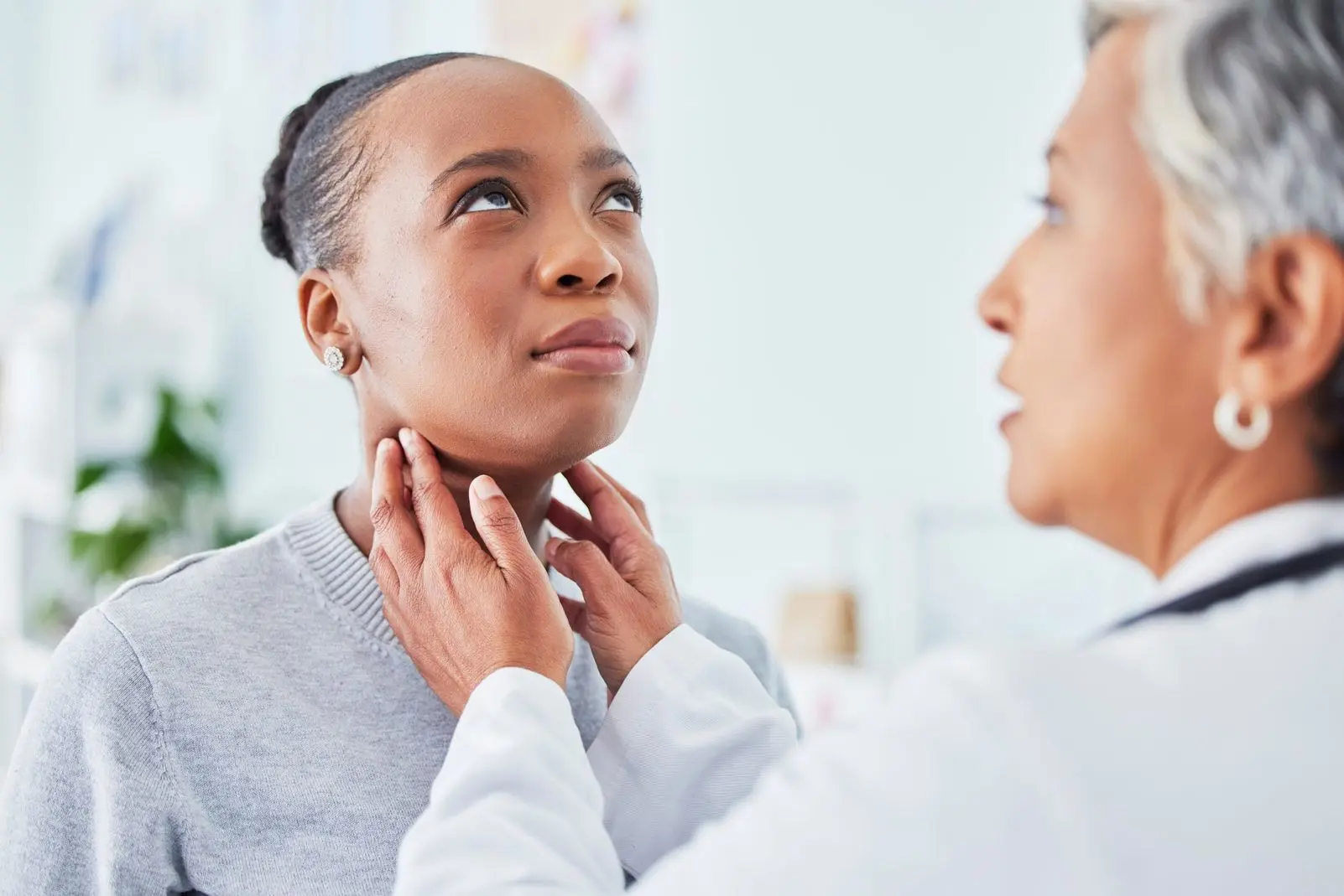 sore-throat-doctor-and-woman-patient-in-hospital-2025-04-06-09-04-00-utc Woman getting treatment for hypothyroidism symptoms.