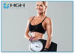 Female body builder holding a scale with both hands to represent weight loss and show muscle gain.