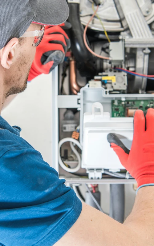 plumber repairing a tankless water heater in OK