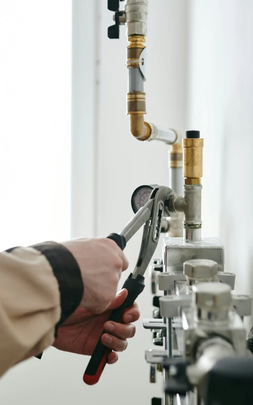 plumber using tools to fix a pipe
