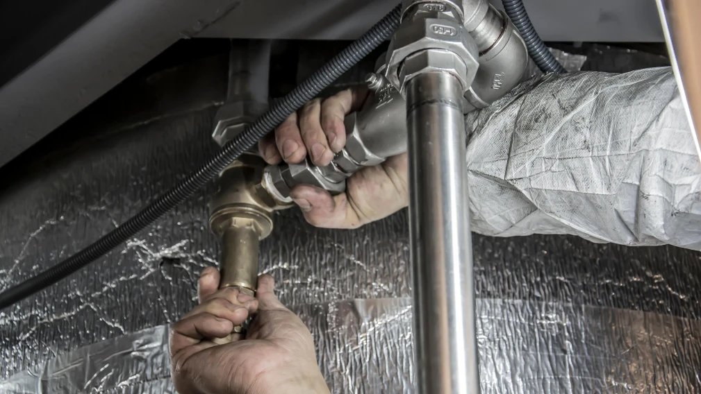 Plumber checking pipe fittings