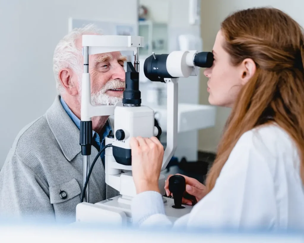 Elderly man undergoing an eye examination with an optometrist.