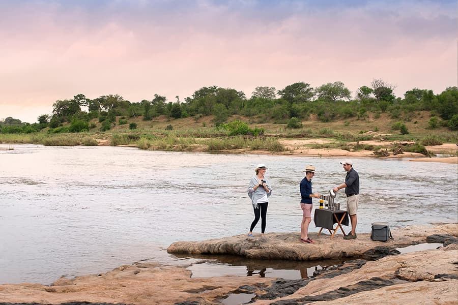 Having drinks at river edge on private safari tour in lion sands, Kruger national park.