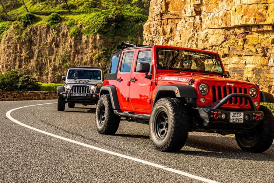 4 wheel drive jeep driving along Chapmans peak in cape town part of exclusive, luxury sightseeing tour