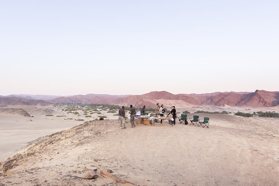 Tour group having sundowners in the desert with stunning view