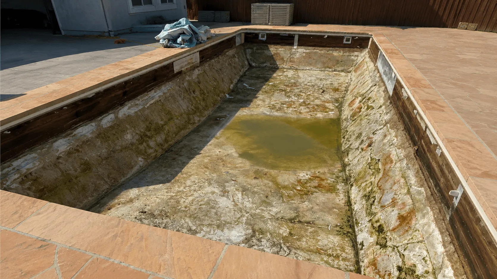 Backyard swimming pool before removal and artificial turf installation in San Diego