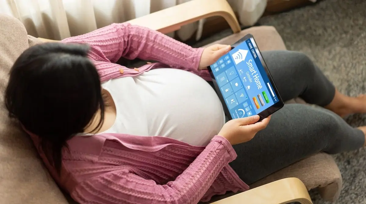 Smart home technology, centric remote control system digital dashboard being used by pregnant mother